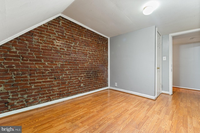 2609 Keyworth Ave, Baltimore, MD 21215 - spare room with brick wall, lofted ceiling, baseboards, and wood finished floors