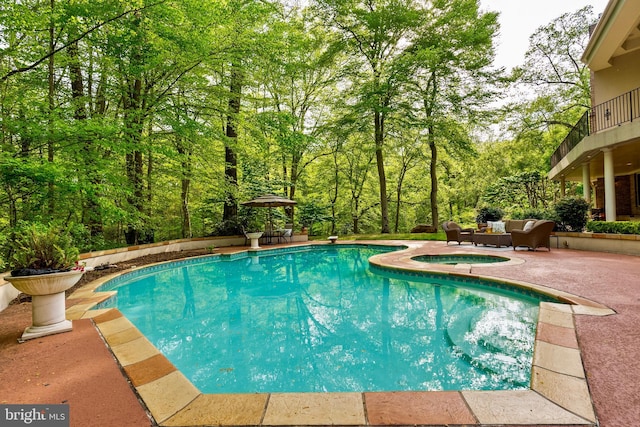 outdoor pool featuring a patio, an in ground hot tub, and outdoor lounge area