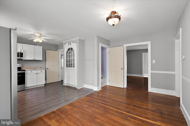 kitchen featuring appliances with stainless steel finishes, a ceiling fan, dark wood-style floors, and baseboards