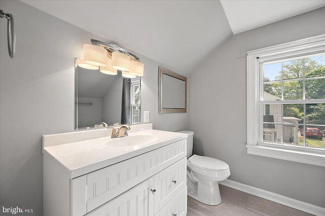 bathroom featuring lofted ceiling, baseboards, toilet, wood finished floors, and vanity