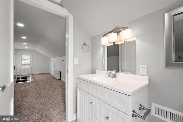 bathroom with recessed lighting, radiator heating unit, vanity, baseboards, and lofted ceiling