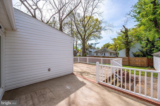 view of patio / terrace with a deck, fence, and a residential view