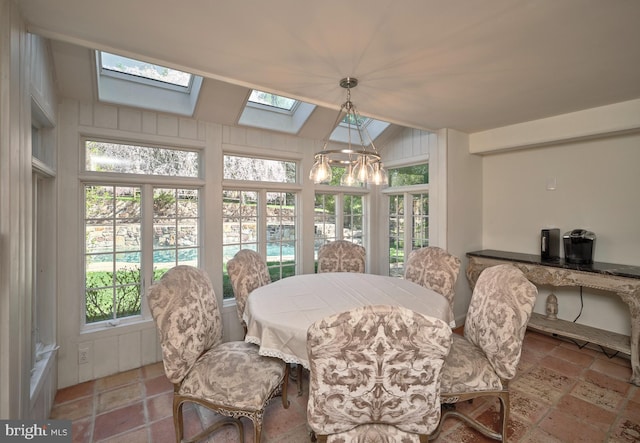 dining area featuring a skylight and a notable chandelier