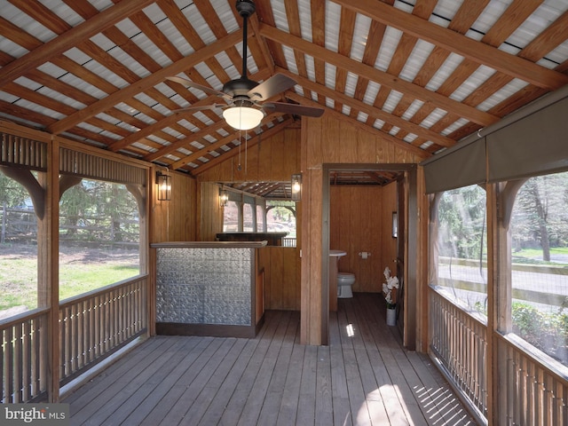 unfurnished sunroom with ceiling fan