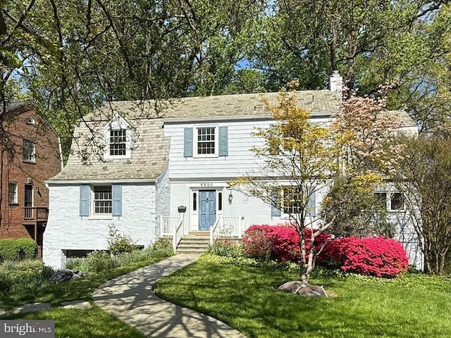 6520 Western Ave, Chevy Chase, MD 20815 - view of front facade featuring a chimney, a front yard, and stone siding