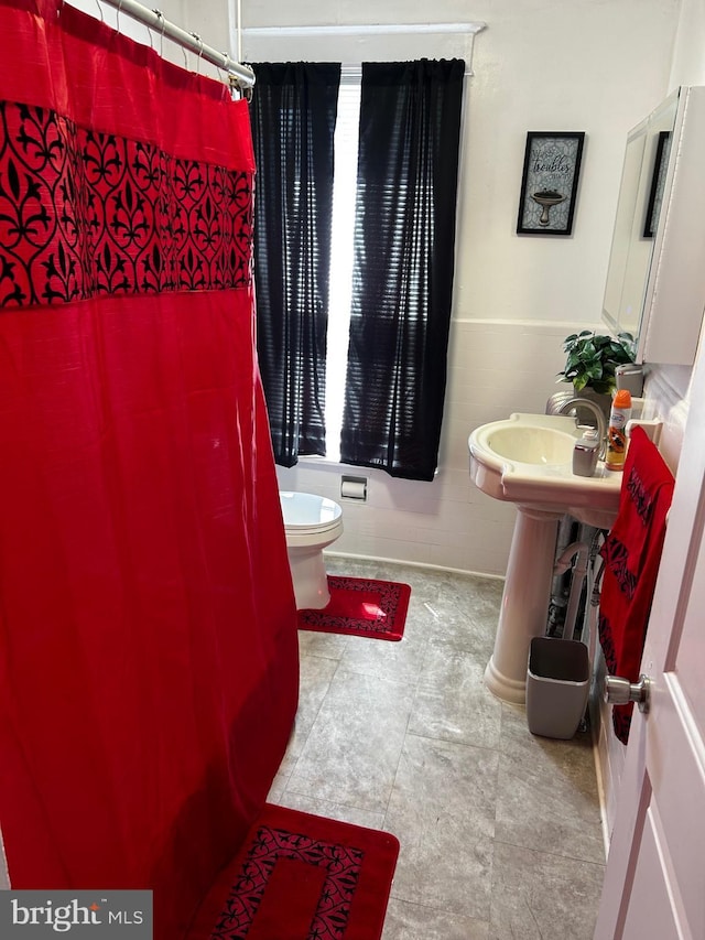 full bath with toilet and a shower with shower curtain