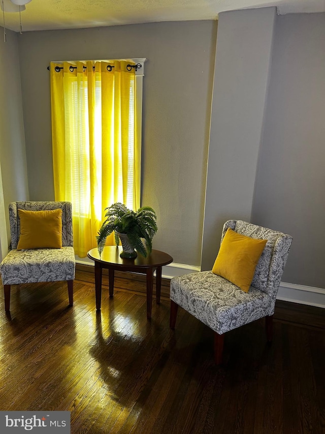 living area featuring baseboards and hardwood / wood-style flooring