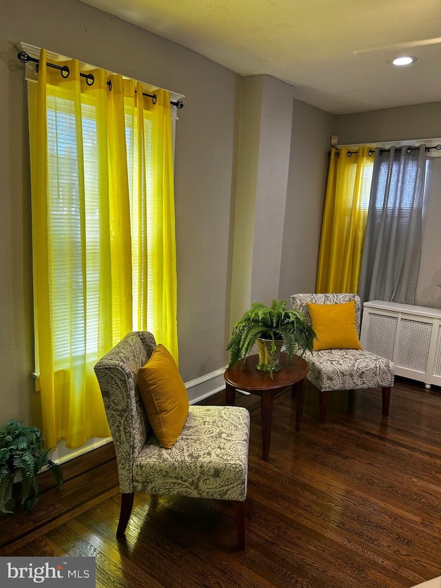 sitting room with radiator heating unit and wood finished floors