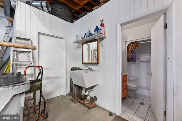 bathroom with walk in shower, toilet, and concrete floors
