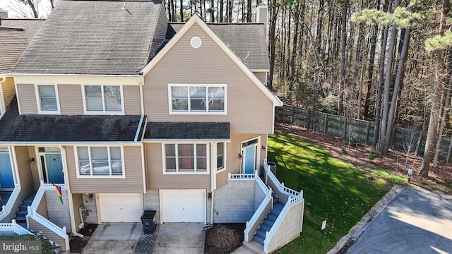 view of front of home featuring driveway, a shingled roof, a garage, and stairs