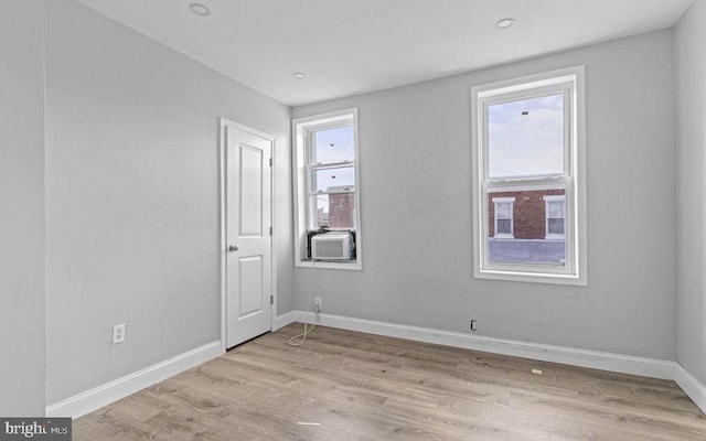 empty room with light wood-style flooring, baseboards, and recessed lighting