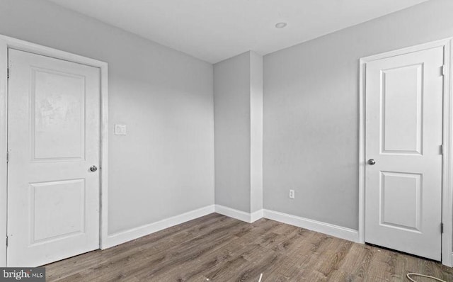 unfurnished bedroom featuring baseboards and wood finished floors