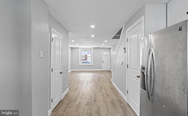 corridor featuring light wood-style floors, baseboards, and recessed lighting