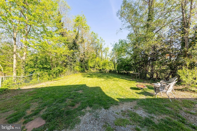 view of yard with fence and an outdoor fire pit