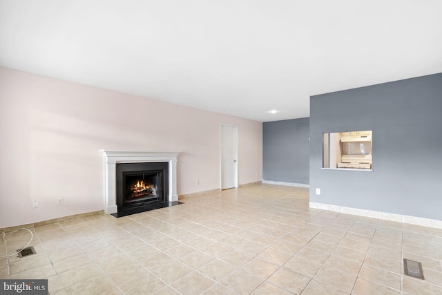 unfurnished living room with light tile patterned flooring, a fireplace with flush hearth, and baseboards
