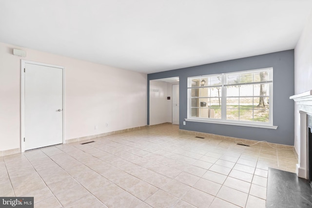 unfurnished living room with light tile patterned floors and a fireplace with flush hearth