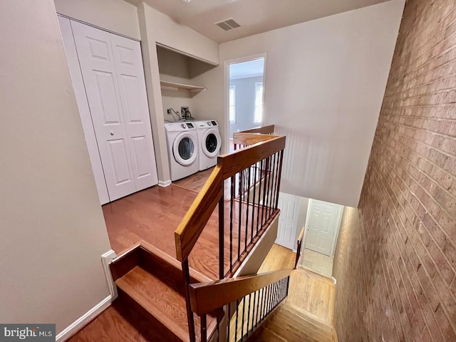2904 11th St NW, Washington, DC 20001 - stairway featuring visible vents, brick wall, wood finished floors, and separate washer and dryer