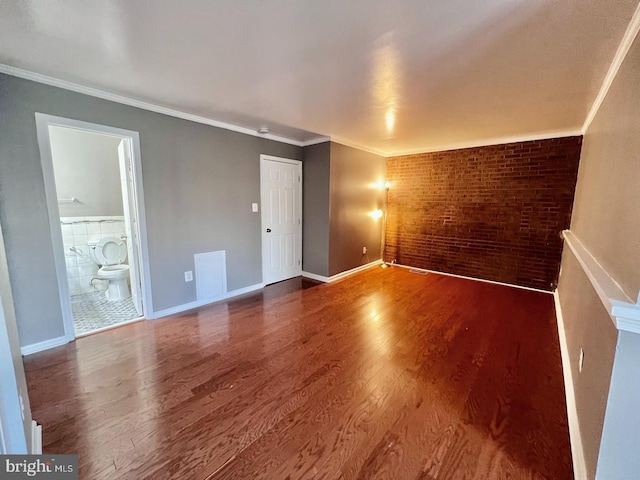 2904 11th St NW, Washington, DC 20001 - spare room with visible vents, brick wall, baseboards, ornamental molding, and wood finished floors