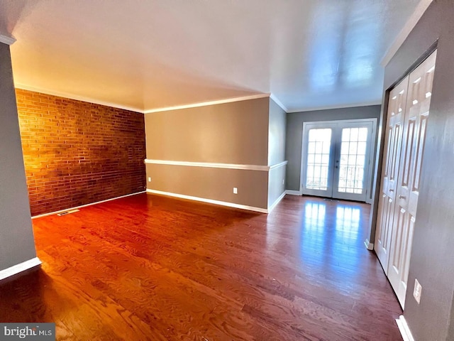 2904 11th St NW, Washington, DC 20001 - empty room featuring wood finished floors, french doors, brick wall, crown molding, and baseboards