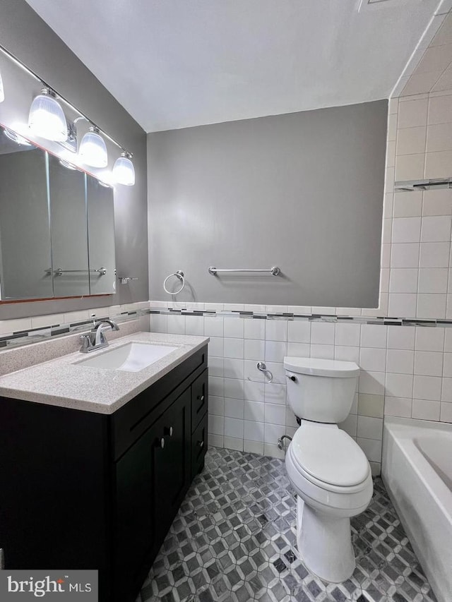2904 11th St NW, Washington, DC 20001 - bathroom featuring vanity, tile walls, toilet, and wainscoting