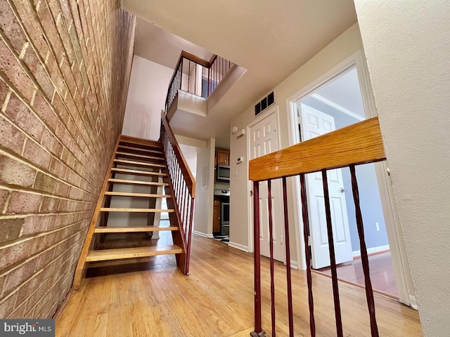 2904 11th St NW, Washington, DC 20001 - stairs with wood finished floors, visible vents, and brick wall
