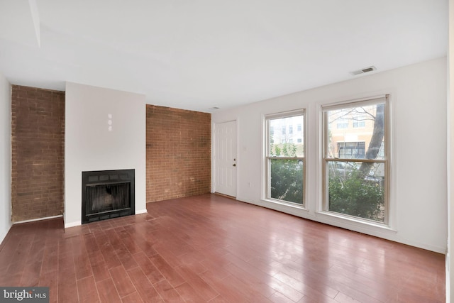 2904 11th St NW, Washington, DC 20001 - unfurnished living room with a fireplace, wood finished floors, visible vents, and brick wall