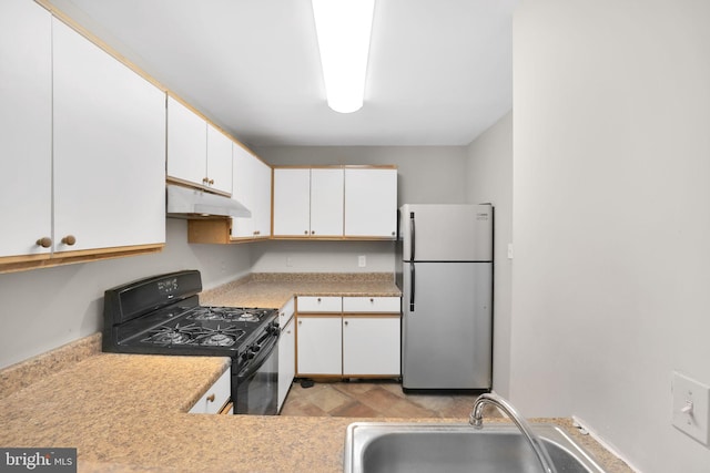 2904 11th St NW, Washington, DC 20001 - kitchen with under cabinet range hood, a sink, freestanding refrigerator, gas stove, and light countertops