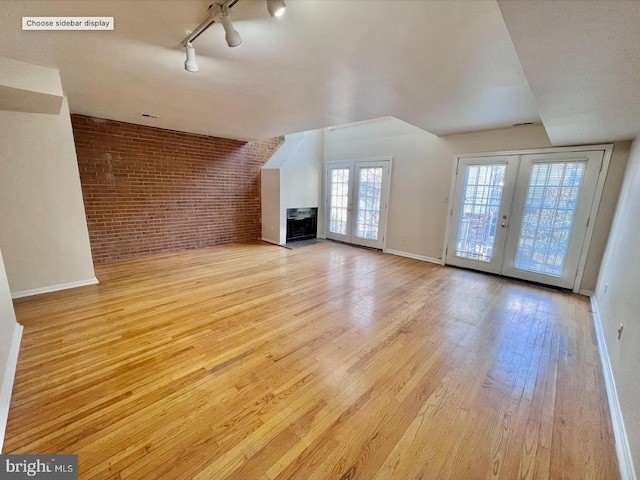 2904 11th St NW, Washington, DC 20001 - unfurnished living room featuring wood finished floors, french doors, brick wall, a fireplace, and baseboards