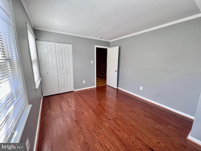 2904 11th St NW, Washington, DC 20001 - unfurnished bedroom featuring a closet, baseboards, wood finished floors, and crown molding
