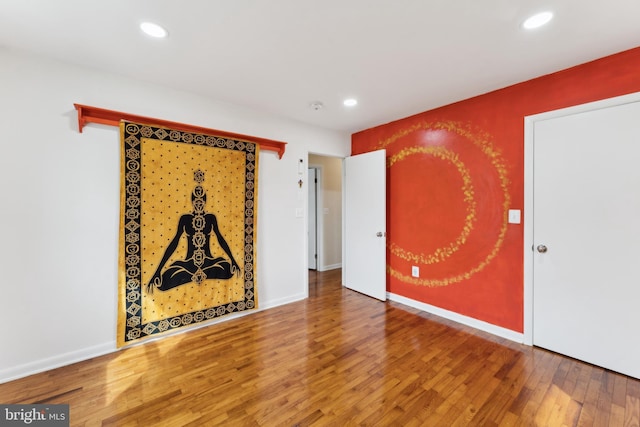 empty room featuring recessed lighting, baseboards, and wood finished floors