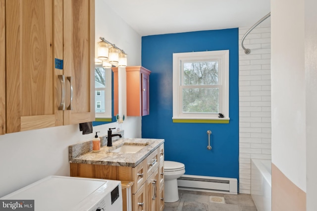 bathroom featuring a baseboard heating unit, toilet, vanity, and stone finish flooring