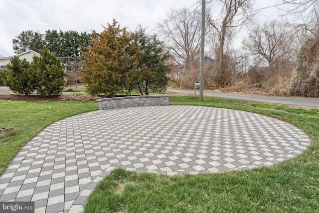 view of property's community featuring a patio and a lawn