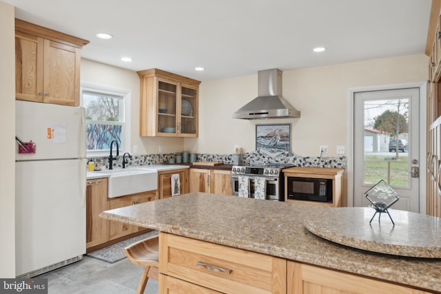 kitchen featuring a sink, freestanding refrigerator, black microwave, wall chimney range hood, and stainless steel electric range oven