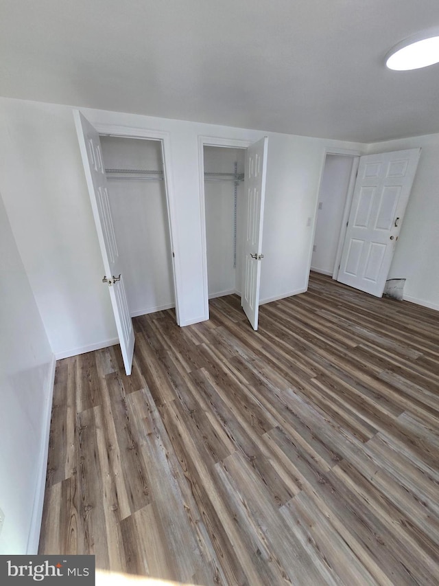 325 W Washington St, Tamaqua, PA 18252 - unfurnished bedroom with wood finished floors, baseboards, and two closets