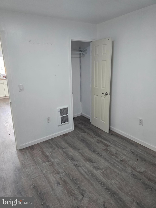 325 W Washington St, Tamaqua, PA 18252 - unfurnished bedroom featuring dark wood finished floors, visible vents, a closet, and baseboards