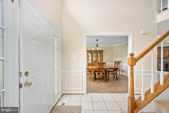 11 Ashbrook Rd, Stafford, VA 22554 - entrance foyer featuring light tile patterned floors, stairway, crown molding, a chandelier, and wainscoting