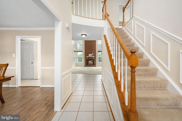 11 Ashbrook Rd, Stafford, VA 22554 - staircase featuring ornamental molding, a fireplace, baseboards, and tile patterned floors