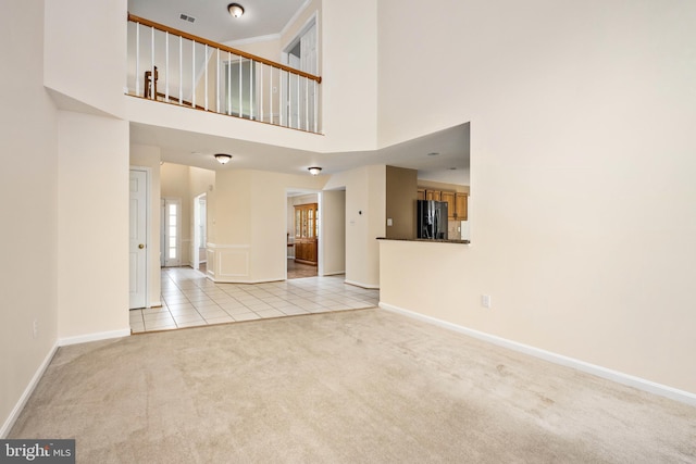 11 Ashbrook Rd, Stafford, VA 22554 - unfurnished living room with carpet, baseboards, tile patterned flooring, and a towering ceiling