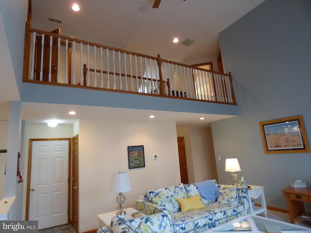 living room with visible vents, recessed lighting, ceiling fan, a high ceiling, and baseboards