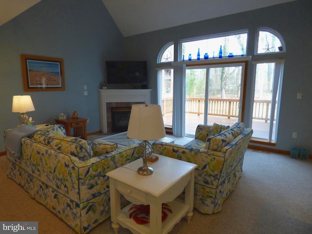living room featuring baseboards, visible vents, vaulted ceiling, a tile fireplace, and carpet floors