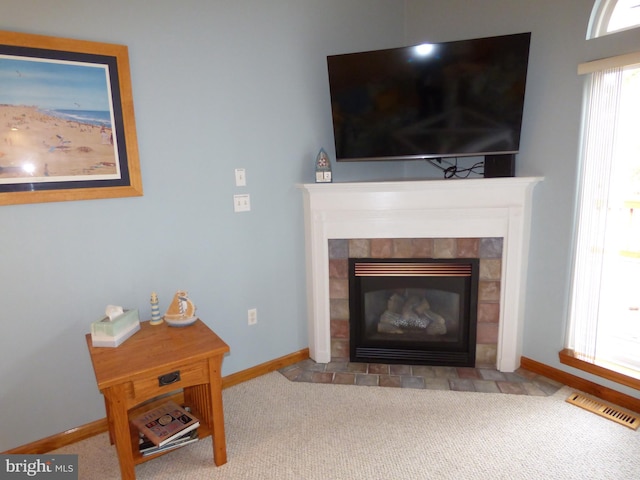 details with carpet flooring, a tiled fireplace, visible vents, and baseboards