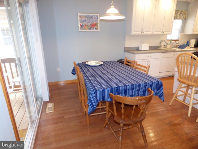 dining area featuring light wood-style flooring, baseboards, and visible vents