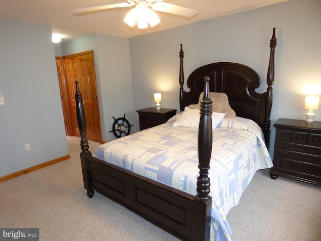 bedroom featuring light colored carpet, baseboards, and ceiling fan