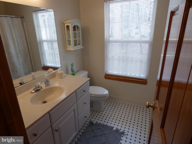 bathroom featuring plenty of natural light, toilet, and vanity