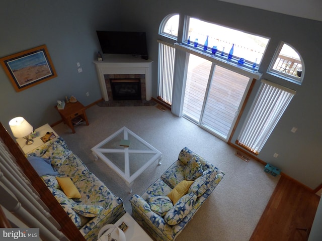 carpeted living area featuring visible vents and a tile fireplace