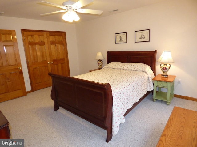 carpeted bedroom with visible vents, baseboards, and a ceiling fan