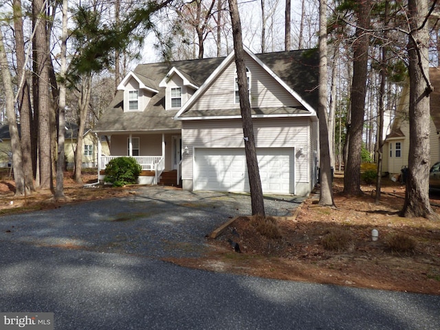 view of front of home featuring a porch, driveway, and a garage