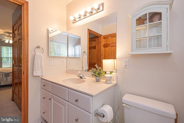 bathroom with toilet, vanity, and ceiling fan