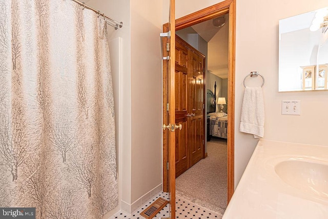 ensuite bathroom with curtained shower, ensuite bathroom, tile patterned flooring, and vanity