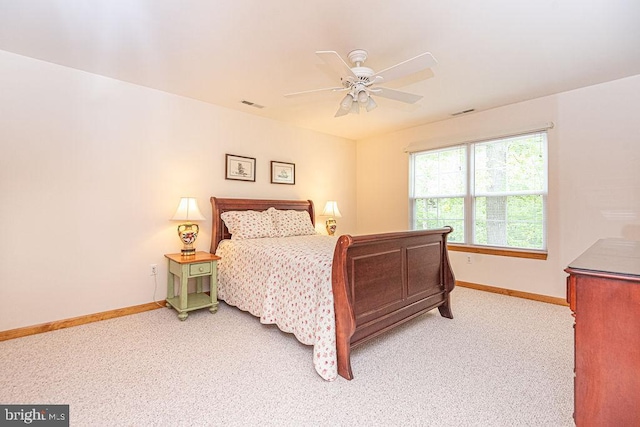 carpeted bedroom featuring baseboards, a ceiling fan, and visible vents